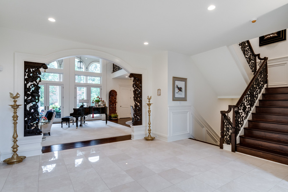 This is an example of a classic foyer in DC Metro with beige walls, marble flooring and beige floors.