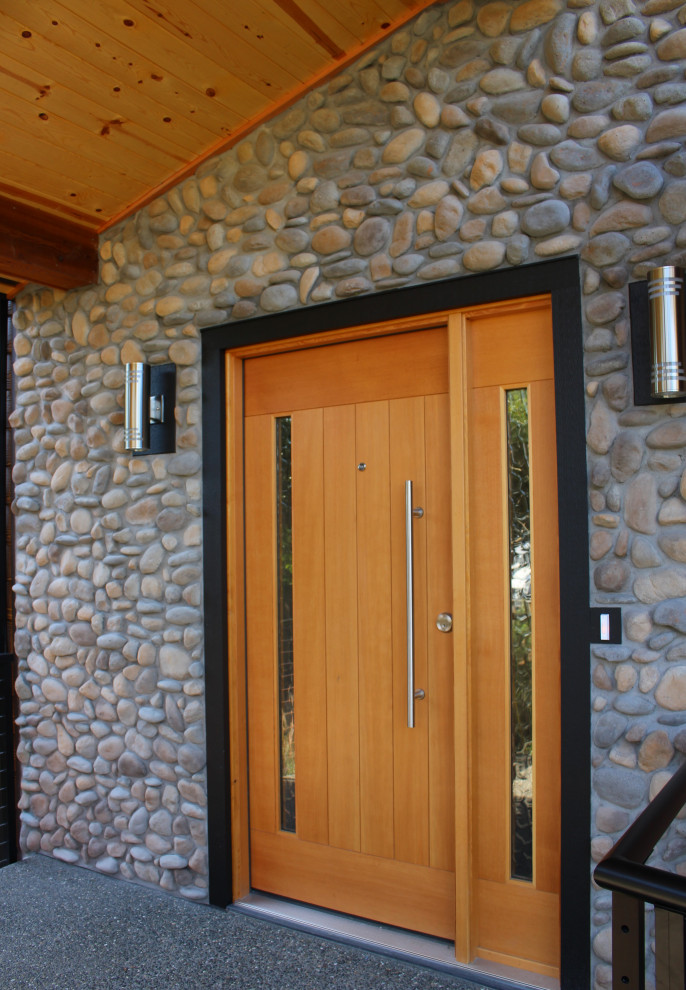 シアトルにあるラグジュアリーな広いミッドセンチュリースタイルのおしゃれな玄関ドア (マルチカラーの壁、コンクリートの床、木目調のドア、塗装板張りの天井、レンガ壁) の写真