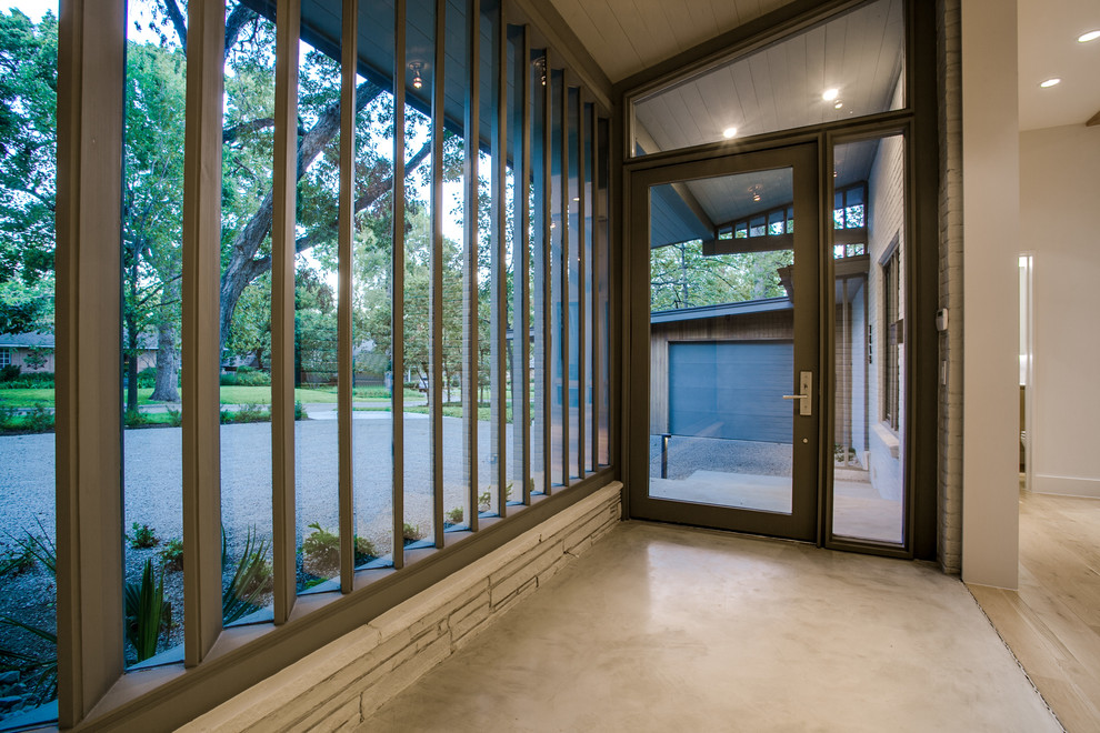 Пример оригинального дизайна: входная дверь среднего размера в современном стиле с бежевыми стенами, бетонным полом, одностворчатой входной дверью, стеклянной входной дверью и бежевым полом