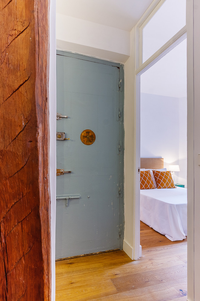 Inspiration pour un petit hall d'entrée vintage avec un mur blanc, un sol en bois brun, une porte simple et une porte bleue.
