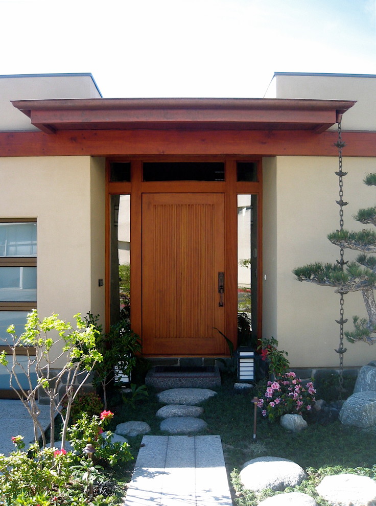 Kleine Asiatische Haustür mit weißer Wandfarbe, Granitboden, Drehtür und hellbrauner Holzhaustür in Los Angeles