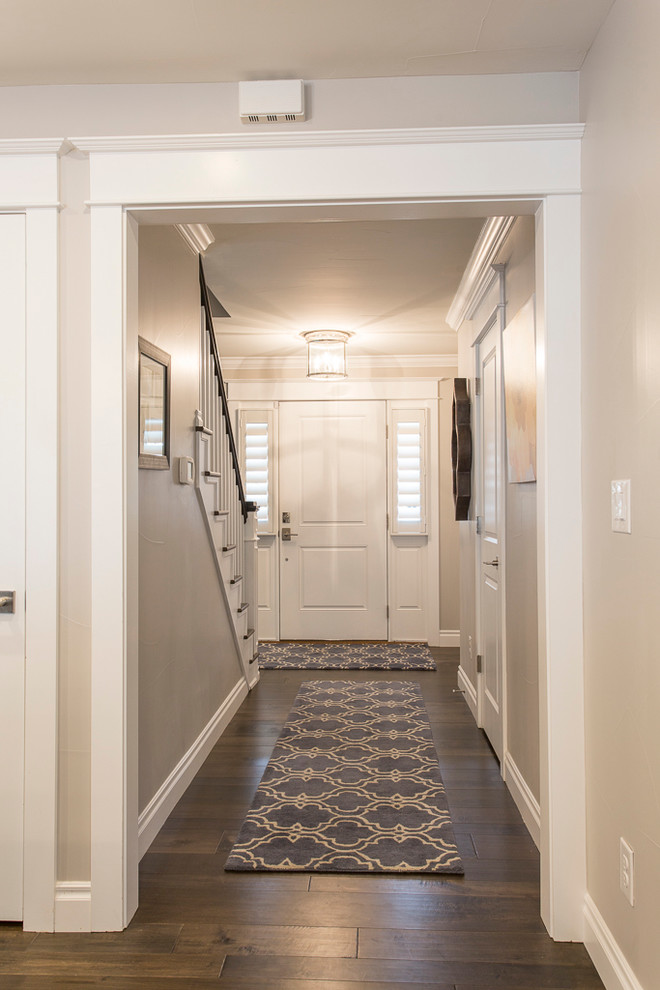 デンバーにある高級な広いトランジショナルスタイルのおしゃれな玄関ロビー (グレーの壁、無垢フローリング、白いドア、茶色い床) の写真