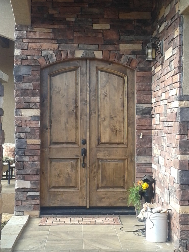 Example of a mid-sized tuscan entryway design in Albuquerque with beige walls and a dark wood front door