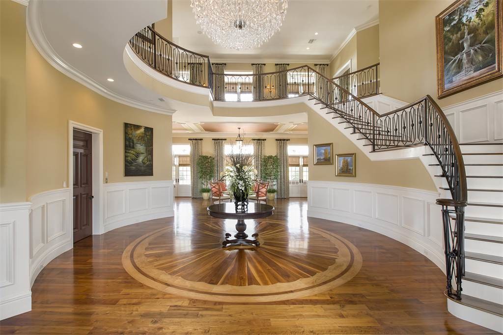 Huge elegant medium tone wood floor and brown floor foyer photo in Orlando with beige walls