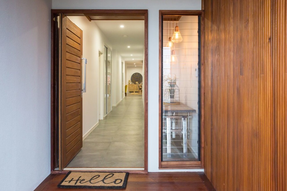 Idées déco pour une porte d'entrée contemporaine de taille moyenne avec un mur blanc, une porte pivot et une porte en bois brun.