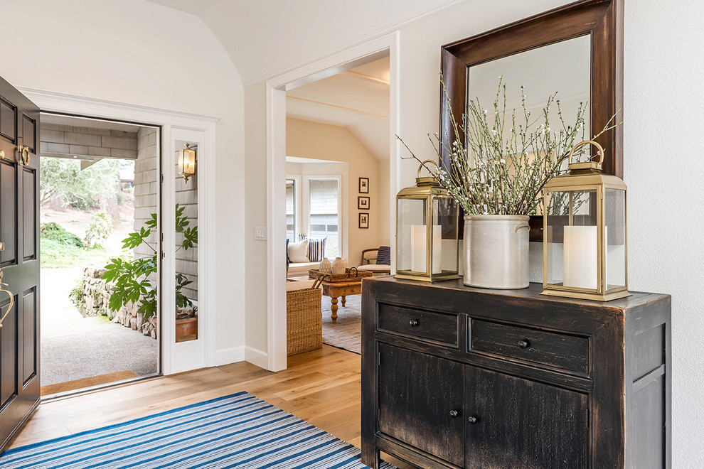 Entryway - farmhouse medium tone wood floor and brown floor entryway idea in Other with beige walls and a black front door