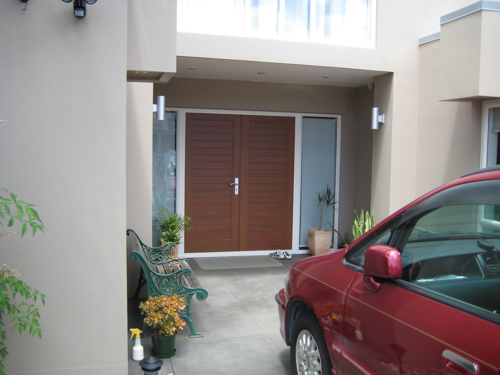 Immagine di una porta d'ingresso minimalista con una porta a due ante e una porta marrone