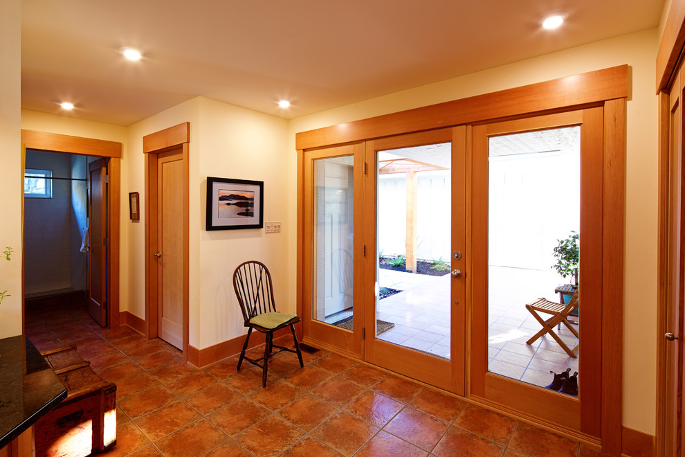 Источник вдохновения для домашнего уюта: большая входная дверь в стиле кантри с белыми стенами, полом из терракотовой плитки, одностворчатой входной дверью и входной дверью из дерева среднего тона
