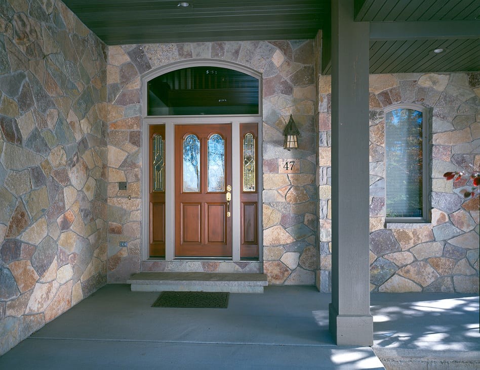他の地域にある高級な広いトラディショナルスタイルのおしゃれな玄関ドア (マルチカラーの壁、コンクリートの床、木目調のドア、グレーの床) の写真