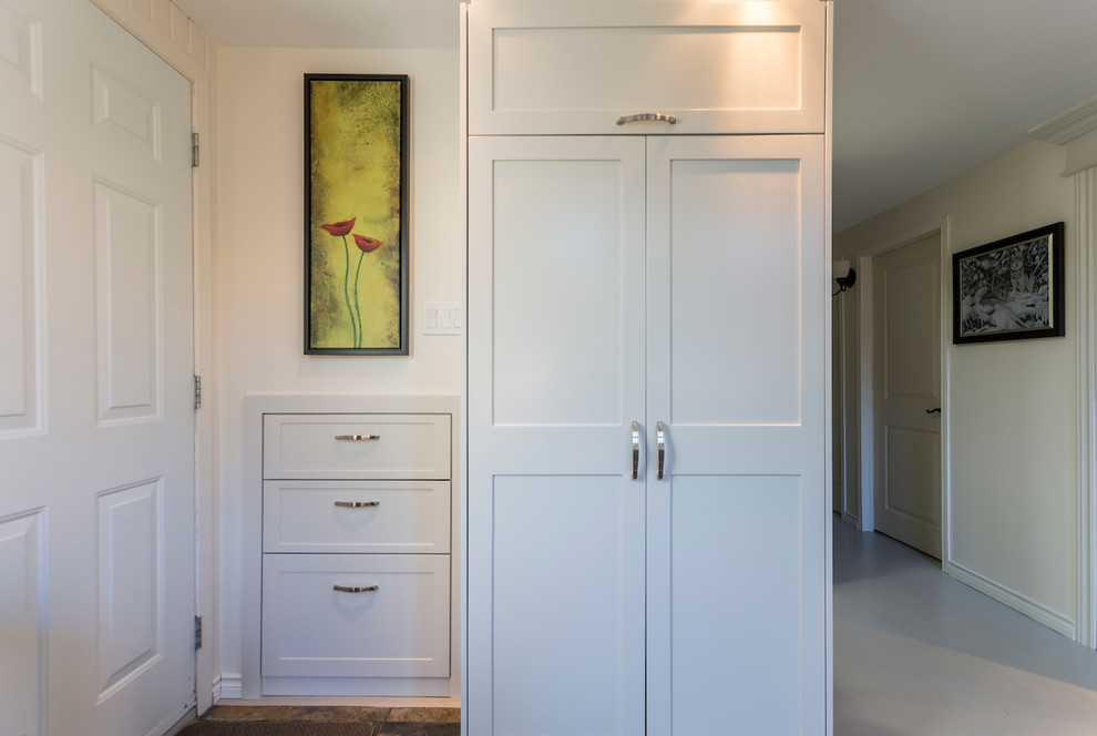 Photo of a small traditional vestibule in Montreal with white walls, painted wood flooring, a single front door, a white front door and beige floors.