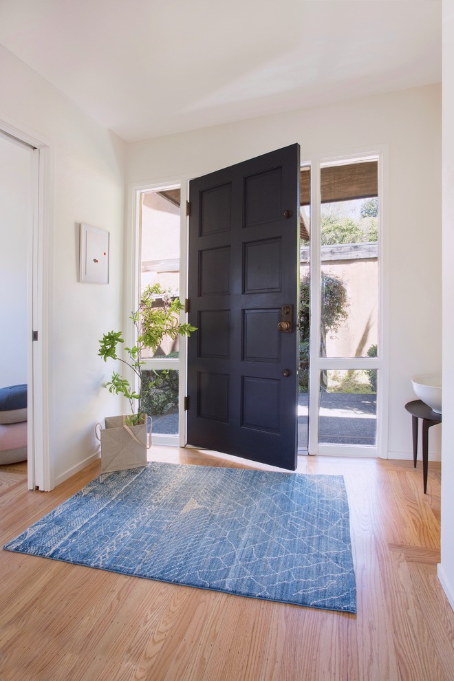 Пример оригинального дизайна: маленькая входная дверь в стиле кантри с белыми стенами, светлым паркетным полом, одностворчатой входной дверью, синей входной дверью и коричневым полом для на участке и в саду