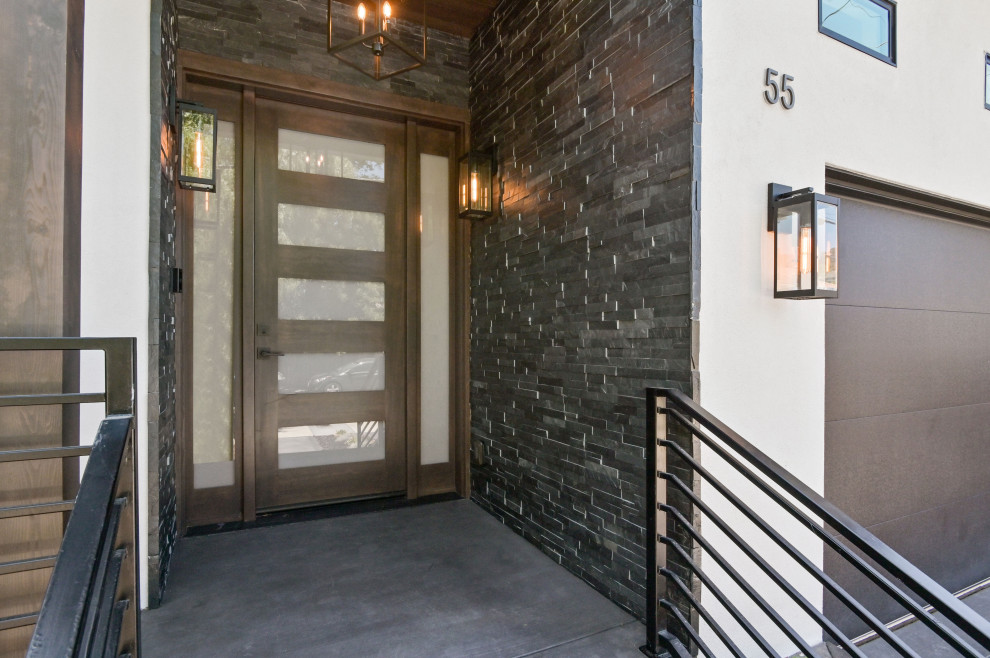 Exempel på en modern ingång och ytterdörr, med grå väggar, betonggolv, en enkeldörr, mellanmörk trädörr och grått golv