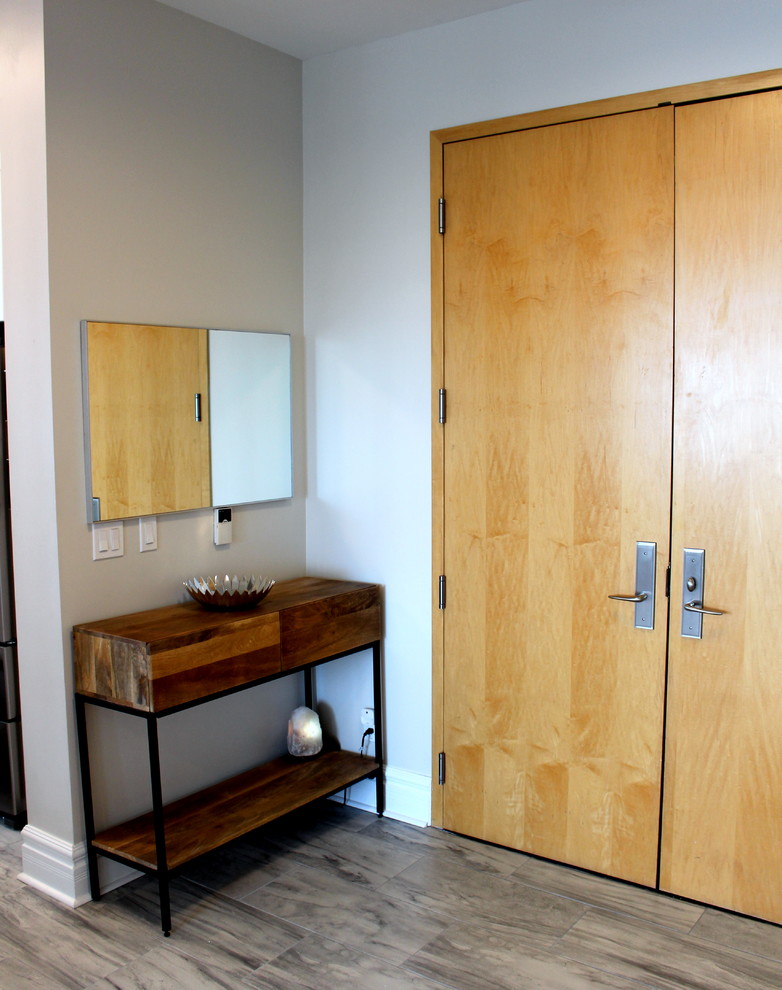Exemple d'un hall d'entrée tendance de taille moyenne avec un mur gris, un sol en carrelage de porcelaine, une porte double, une porte en bois clair et un sol gris.