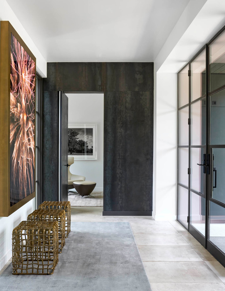 На фото: большая узкая прихожая в современном стиле с белыми стенами, одностворчатой входной дверью, стеклянной входной дверью, серым полом и бетонным полом