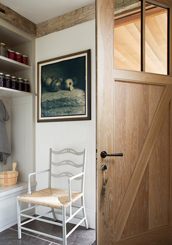 Foto på ett litet lantligt kapprum, med vita väggar, skiffergolv, en enkeldörr, ljus trädörr och svart golv