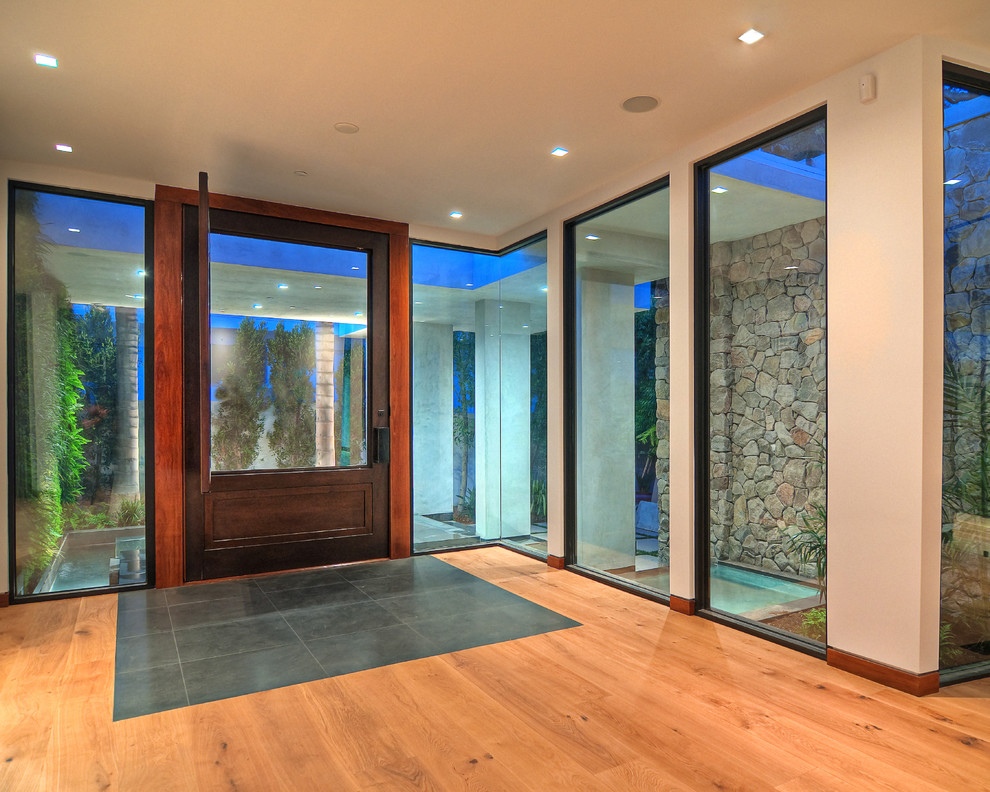 Источник вдохновения для домашнего уюта: большая входная дверь в современном стиле с бежевыми стенами, паркетным полом среднего тона, поворотной входной дверью, стеклянной входной дверью и коричневым полом