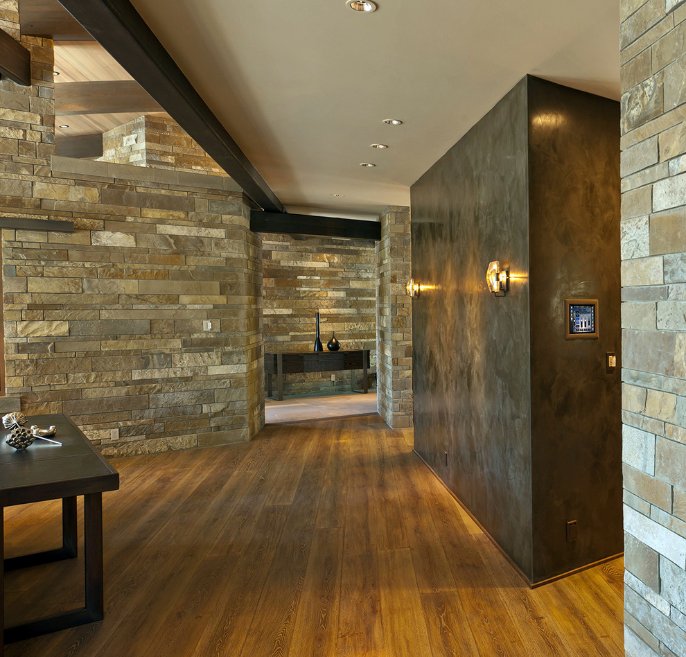 Ispirazione per un grande corridoio minimal con pareti marroni e pavimento in legno massello medio