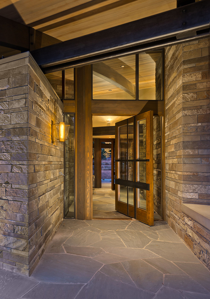 Photo of a large rustic front door in Sacramento with grey walls, a pivot front door, a glass front door and granite flooring.