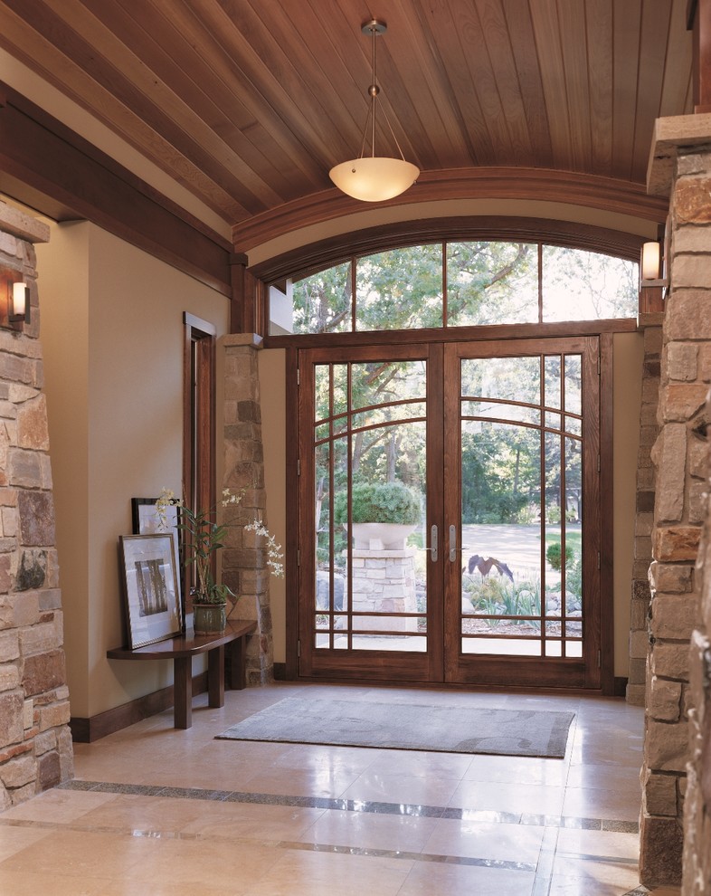 Diseño de puerta principal clásica renovada de tamaño medio con paredes beige, suelo de travertino, puerta doble, puerta de madera en tonos medios y suelo beige