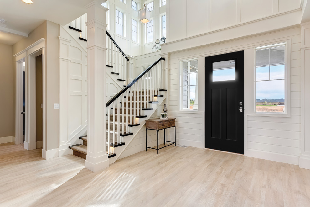 Inspiration for a mid-sized craftsman light wood floor and brown floor entryway remodel in Los Angeles with gray walls and a black front door