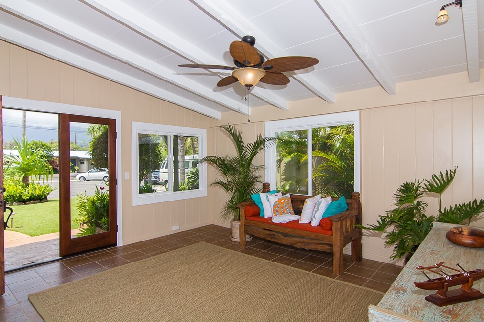 ハワイにある中くらいなトロピカルスタイルのおしゃれな玄関ロビー (ベージュの壁、磁器タイルの床、ガラスドア、茶色い床) の写真