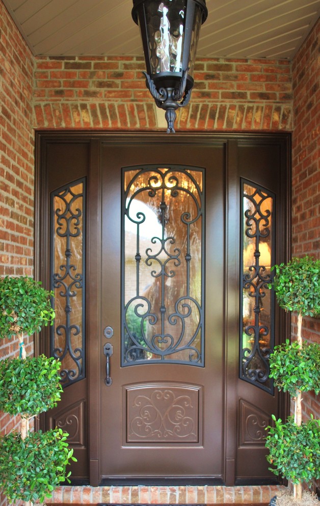 На фото: входная дверь среднего размера в классическом стиле с красными стенами, двустворчатой входной дверью, коричневой входной дверью и красным полом с