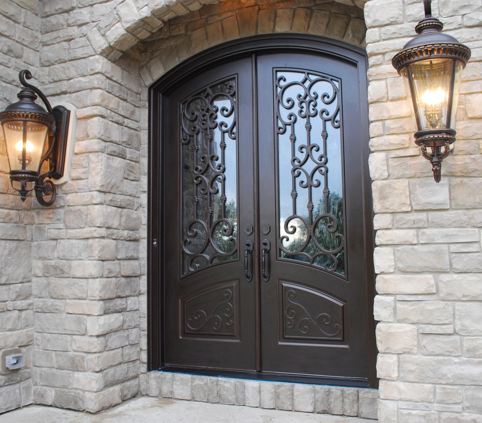 Foto de puerta principal clásica de tamaño medio con paredes beige, suelo de cemento, puerta doble, puerta marrón y suelo gris