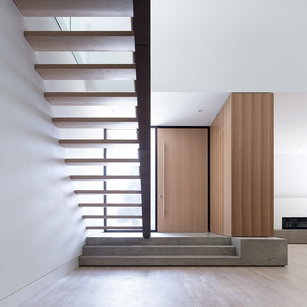 Idées déco pour une porte d'entrée moderne avec un mur blanc, sol en béton ciré, une porte simple et une porte en bois brun.