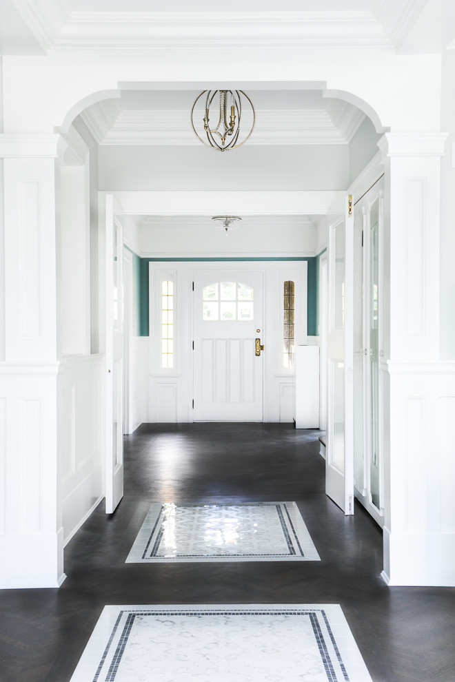 Example of a mid-sized classic medium tone wood floor entryway design in Vancouver with green walls and a white front door