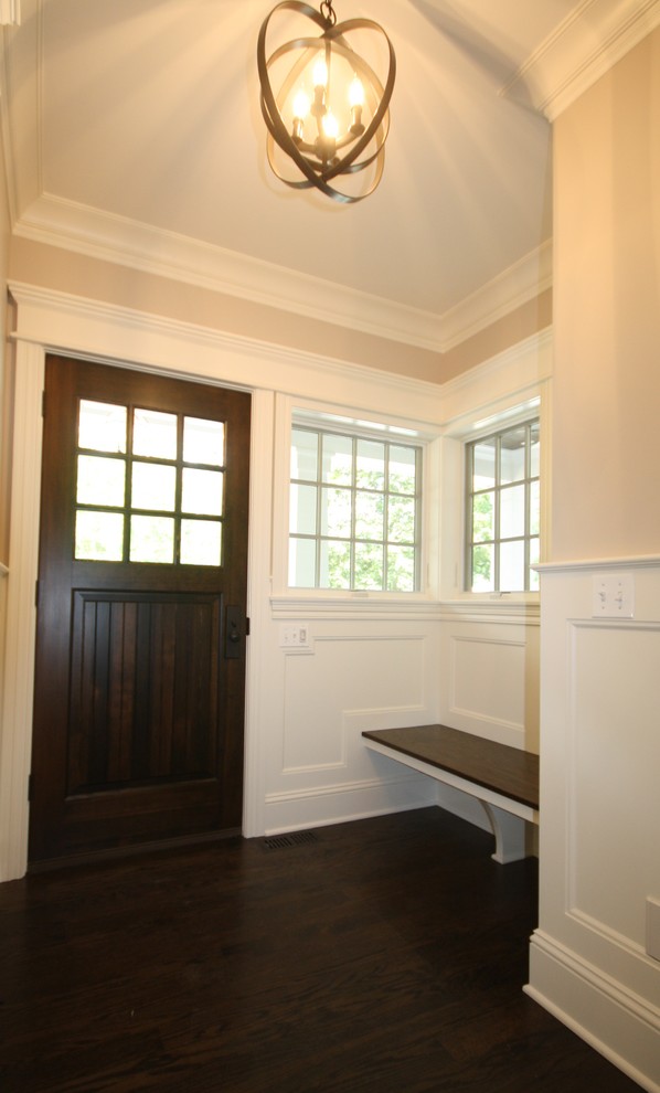 Aménagement d'un hall d'entrée classique de taille moyenne avec un mur beige, parquet foncé, une porte simple, une porte en bois foncé et un sol marron.