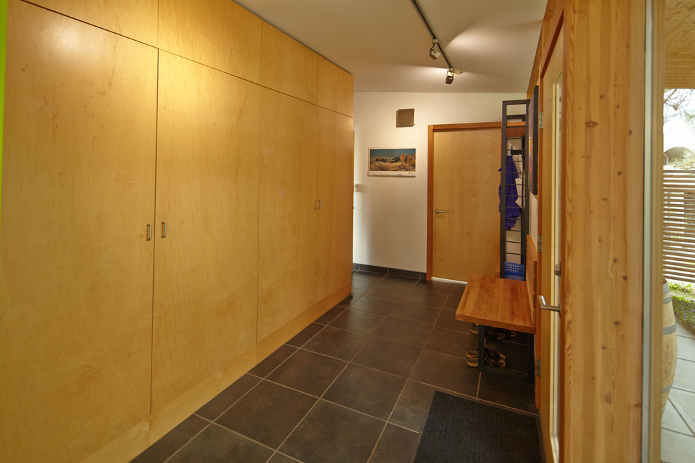 Immagine di un ingresso o corridoio minimalista con pareti bianche e armadio
