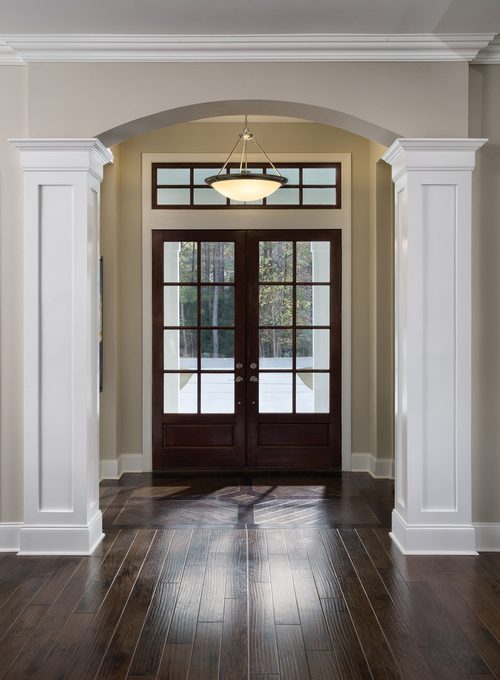チャールストンにある高級な広いトランジショナルスタイルのおしゃれな玄関ドア (ベージュの壁、濃色無垢フローリング、濃色木目調のドア) の写真