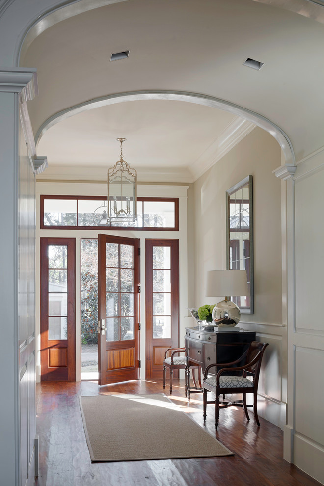 Inspiration for a classic foyer in Atlanta with beige walls, dark hardwood flooring, a single front door, a glass front door and feature lighting.