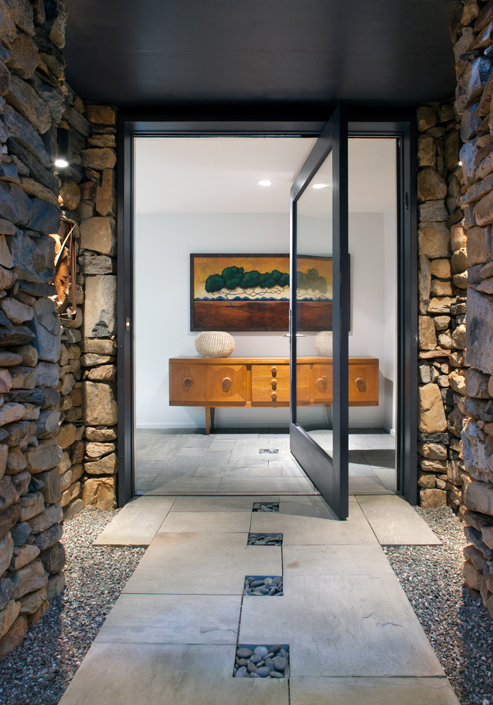 Пример оригинального дизайна: входная дверь среднего размера в современном стиле с поворотной входной дверью, стеклянной входной дверью, бежевыми стенами, полом из сланца и бежевым полом