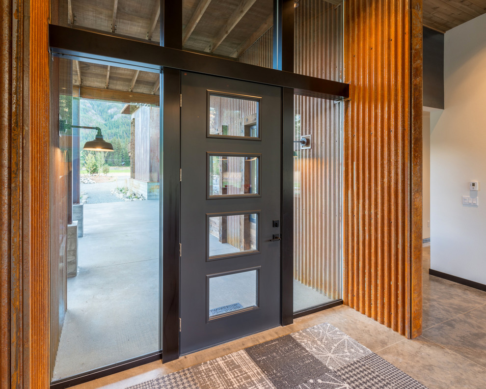 Стильный дизайн: фойе среднего размера в стиле лофт с белыми стенами, бетонным полом, одностворчатой входной дверью, черной входной дверью и бежевым полом - последний тренд