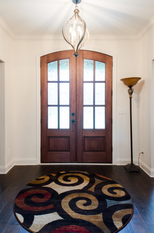 Cette photo montre une porte d'entrée chic de taille moyenne avec un mur blanc, parquet foncé, une porte double, une porte en bois brun et un sol marron.