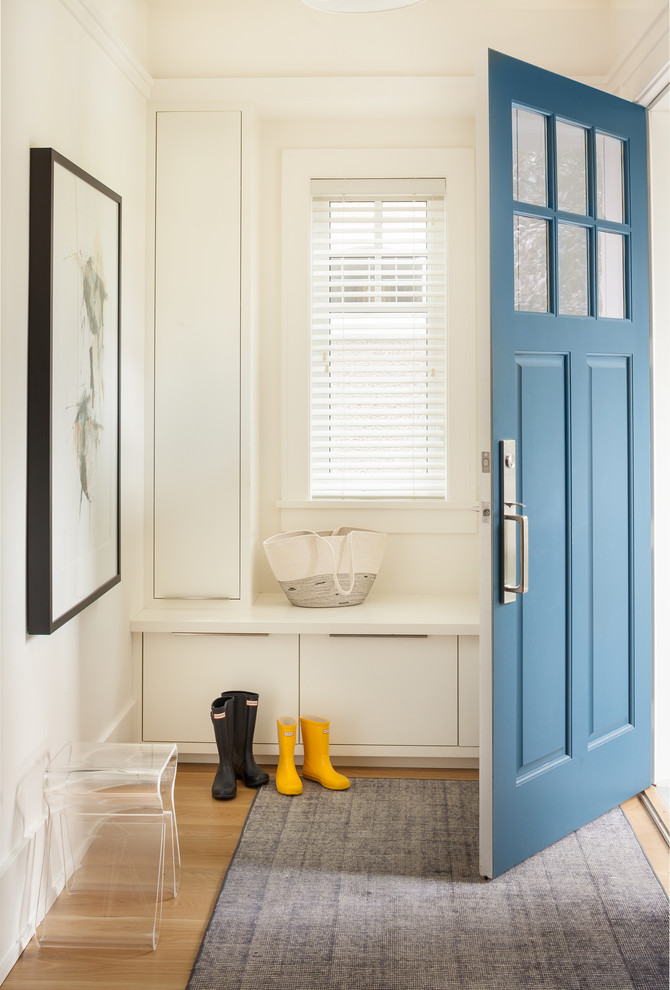 Foto på en liten vintage foajé, med vita väggar, ljust trägolv, en enkeldörr och en blå dörr