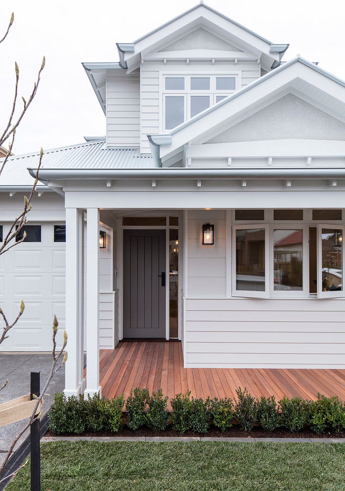 This is an example of a traditional front door in Melbourne with white walls, medium hardwood flooring, a single front door and a grey front door.