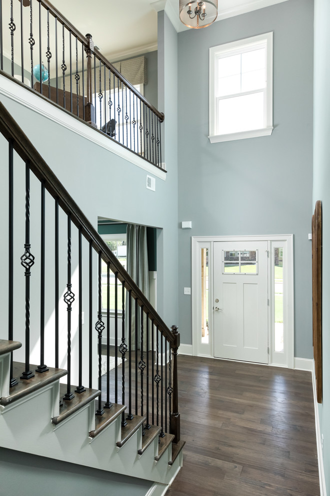 Photo of a large traditional foyer in Other with blue walls, dark hardwood flooring, a single front door, a white front door and brown floors.