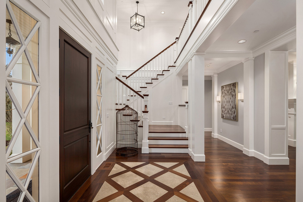 Klassisches Foyer mit weißer Wandfarbe, dunklem Holzboden, Einzeltür, dunkler Holzhaustür und braunem Boden in Seattle
