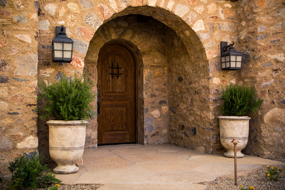 Imagen de puerta principal mediterránea con puerta simple y puerta de madera oscura