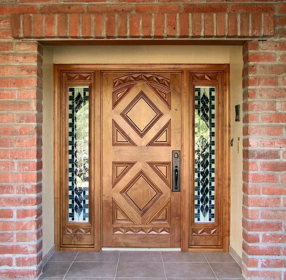 Ispirazione per una porta d'ingresso mediterranea di medie dimensioni con pareti beige, pavimento in gres porcellanato, una porta singola e una porta in legno bruno