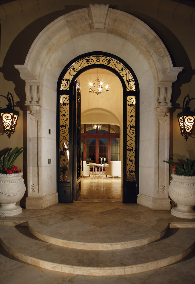 Foto di una grande porta d'ingresso mediterranea con pareti beige, pavimento in travertino, una porta singola e una porta in vetro