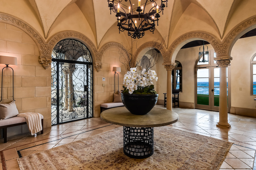 This is an example of a mediterranean foyer in Miami with beige walls and a metal front door.