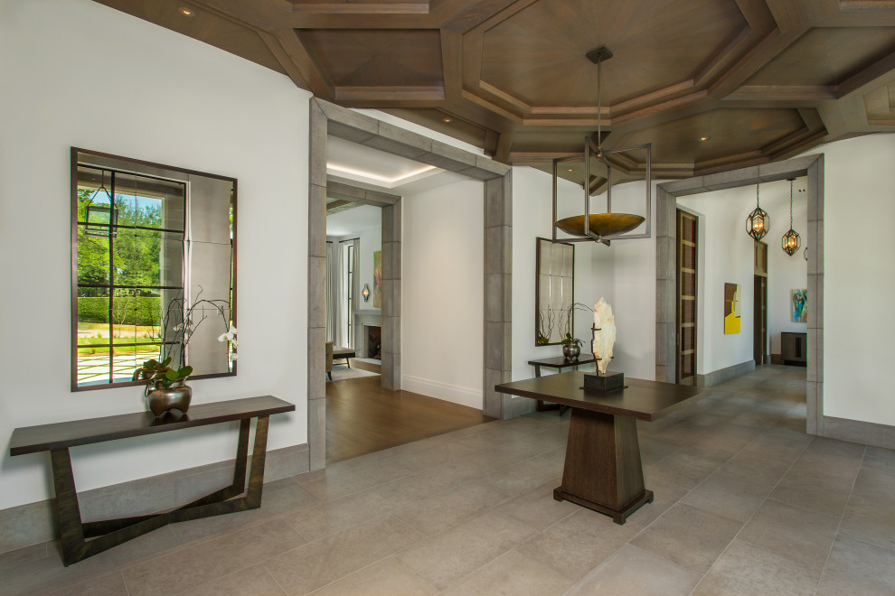 Example of a tuscan gray floor foyer design in Dallas with white walls