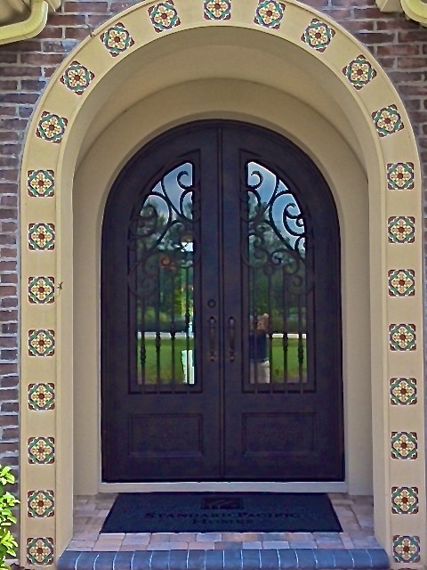 Bild på en stor medelhavsstil entré, med en dubbeldörr och metalldörr