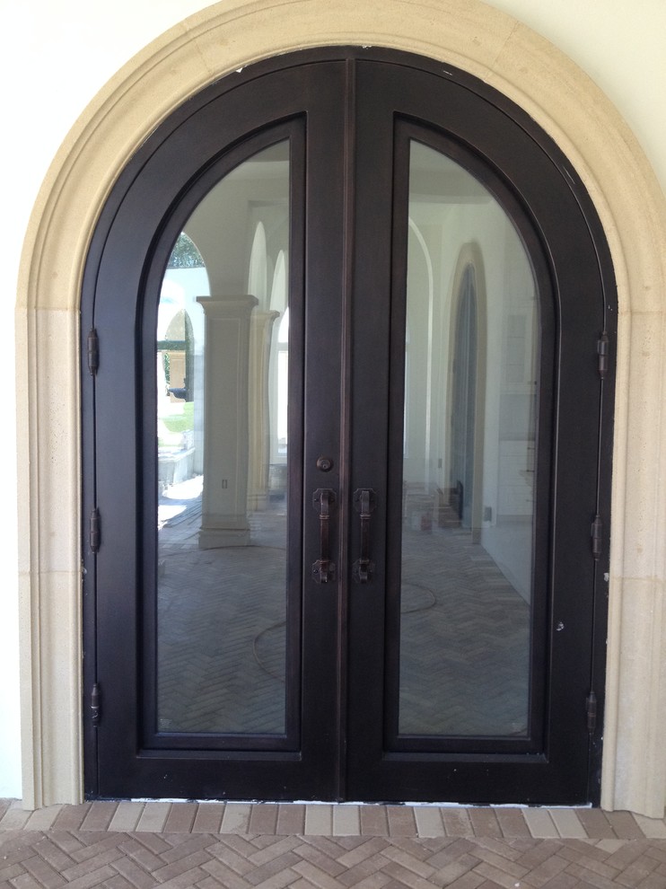 Ejemplo de puerta principal mediterránea grande con puerta doble y puerta metalizada