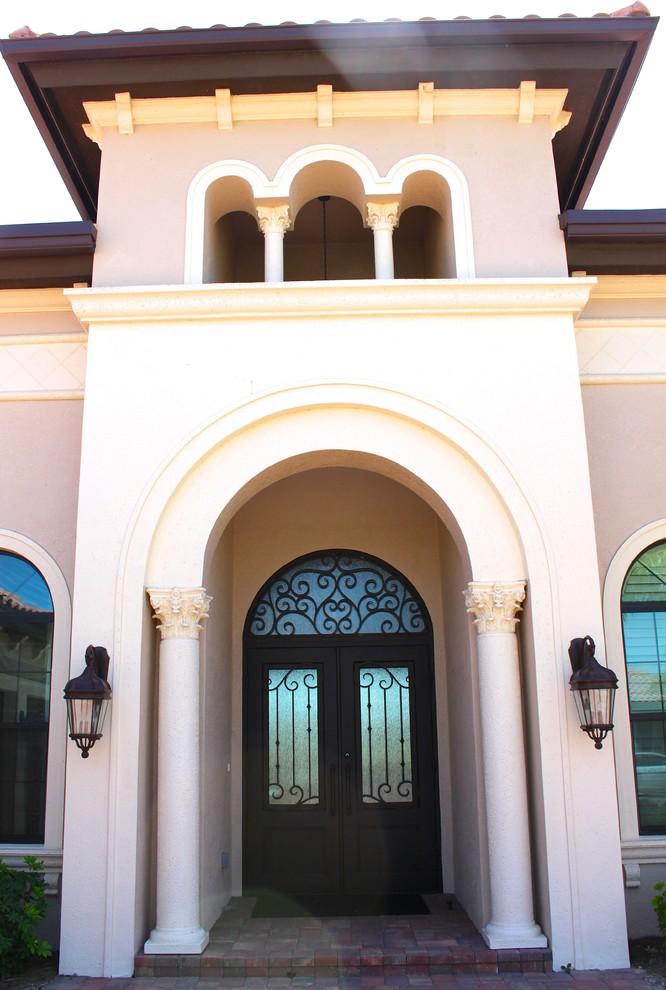Bild på en stor medelhavsstil ingång och ytterdörr, med en dubbeldörr och metalldörr