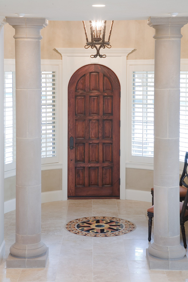 Imagen de puerta principal mediterránea de tamaño medio con paredes beige, puerta simple, puerta de madera en tonos medios y suelo de baldosas de cerámica