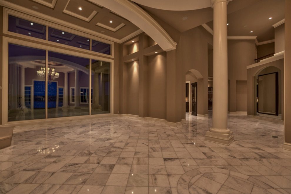 Geräumiges Mediterranes Foyer mit beiger Wandfarbe, Marmorboden, Doppeltür und schwarzer Haustür in Omaha